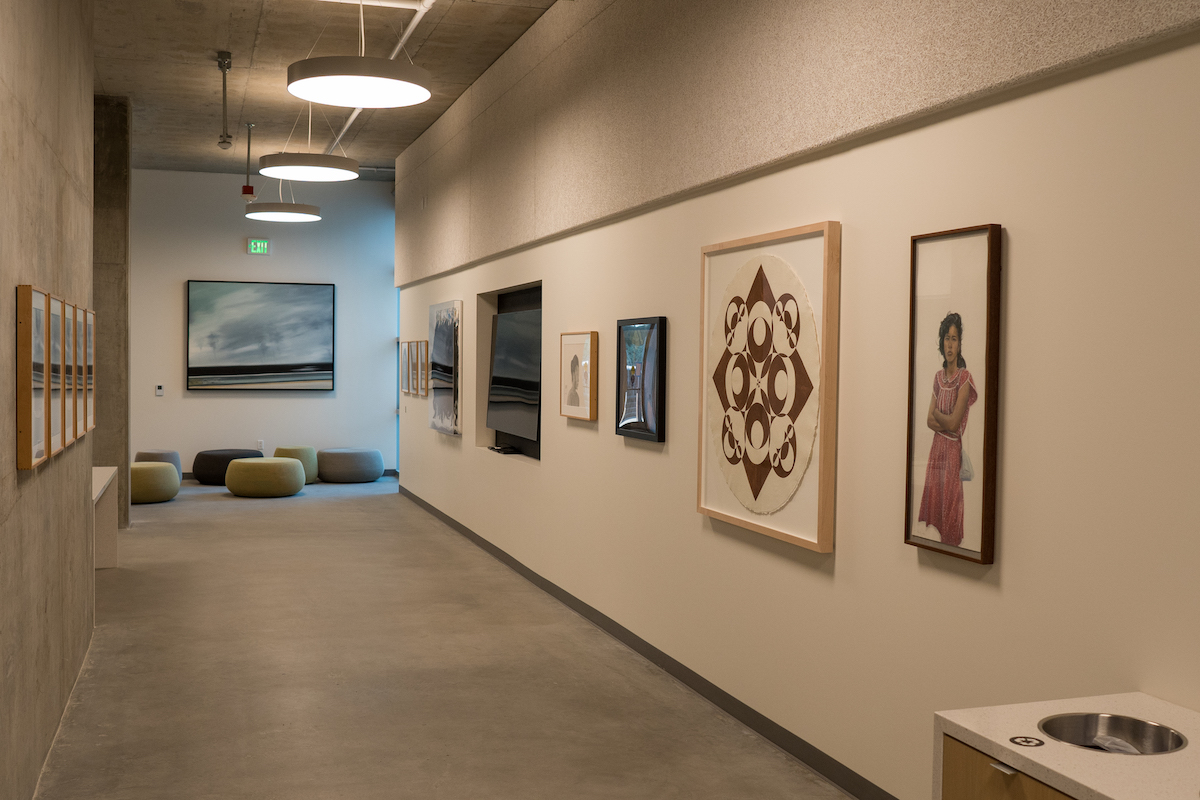 An art gallery hallway with framed artworks on the walls