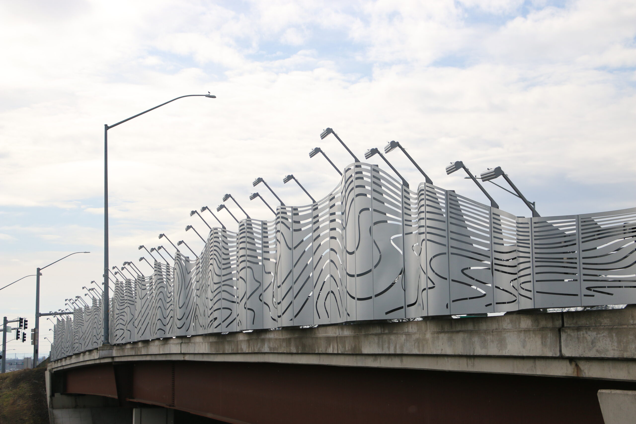 A huge metal sculpture outside above a highway