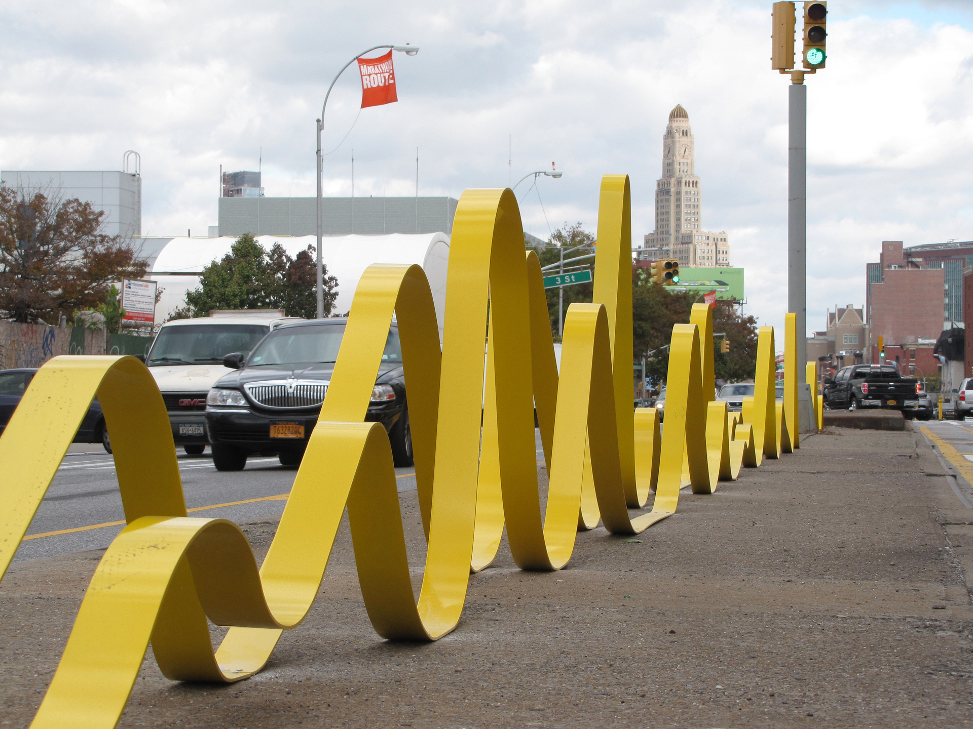 A large bright yellow sculpture outside on the road.
