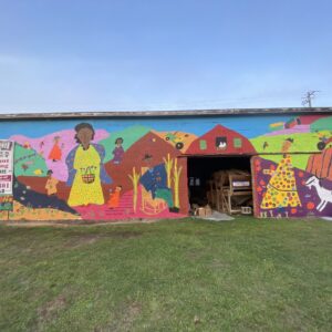 A vibrant mural showcasing various people on the side of a building.