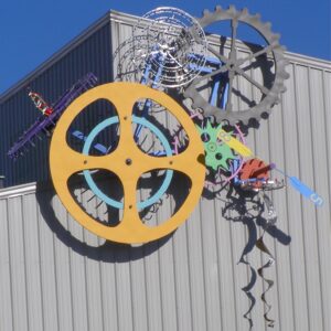 Colorful abstract metal sculpture with gears and industrial elements.