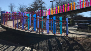 Colorful pedestrian ramp with vibrant vertical railings.