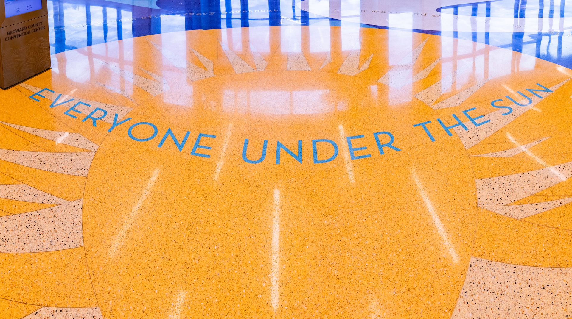 photograph of yellow semi-circle terrazzo floor with words everyone under the sun